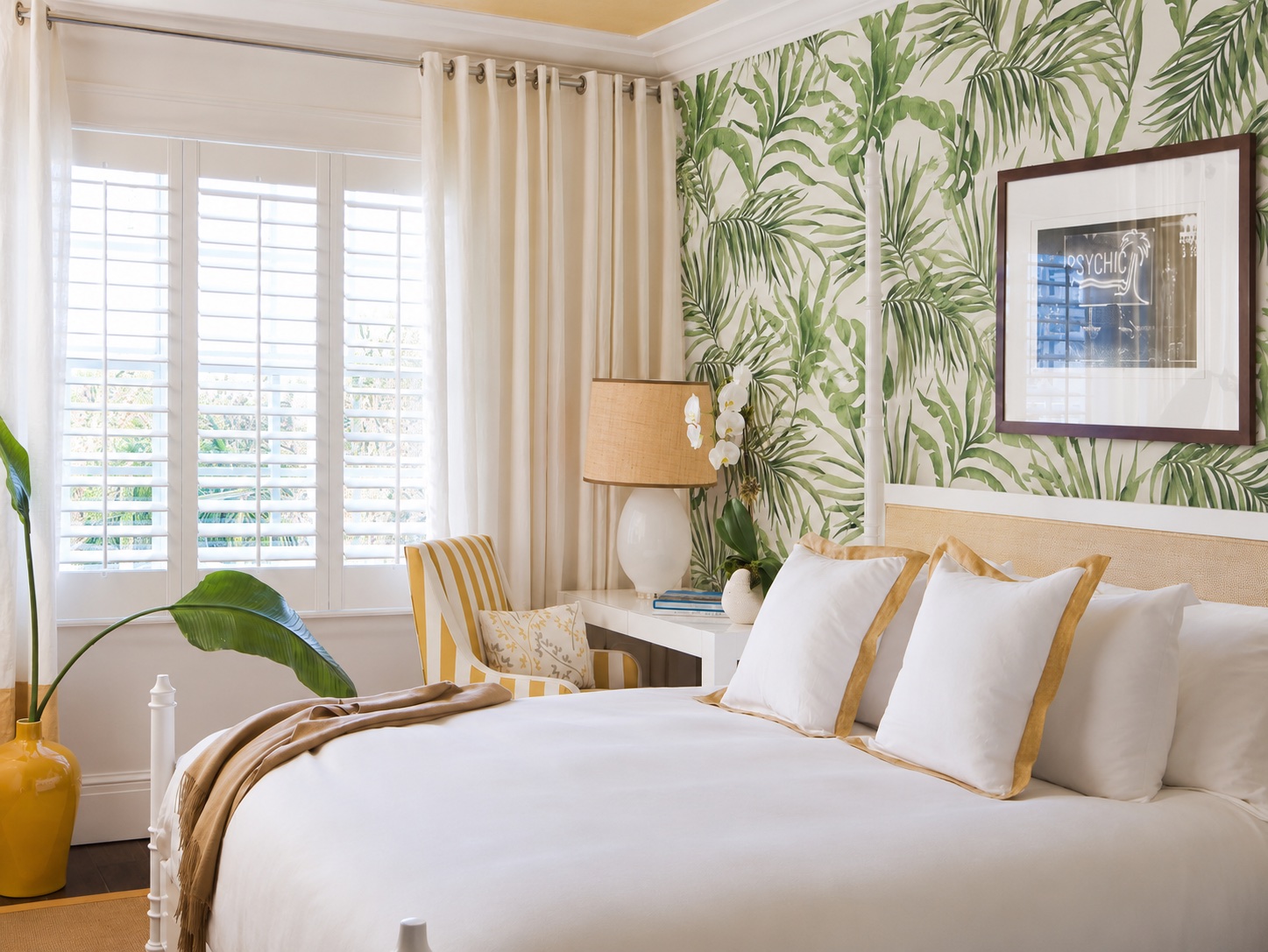 The Betsy Hotel — guest room with palm-leaf wallpaper and a cane headboard