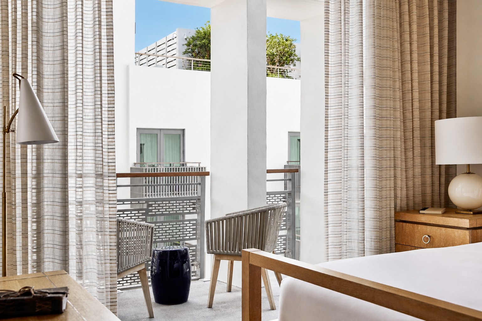 The Carlton Hotel — a guest room with a private balcony and striped drapery